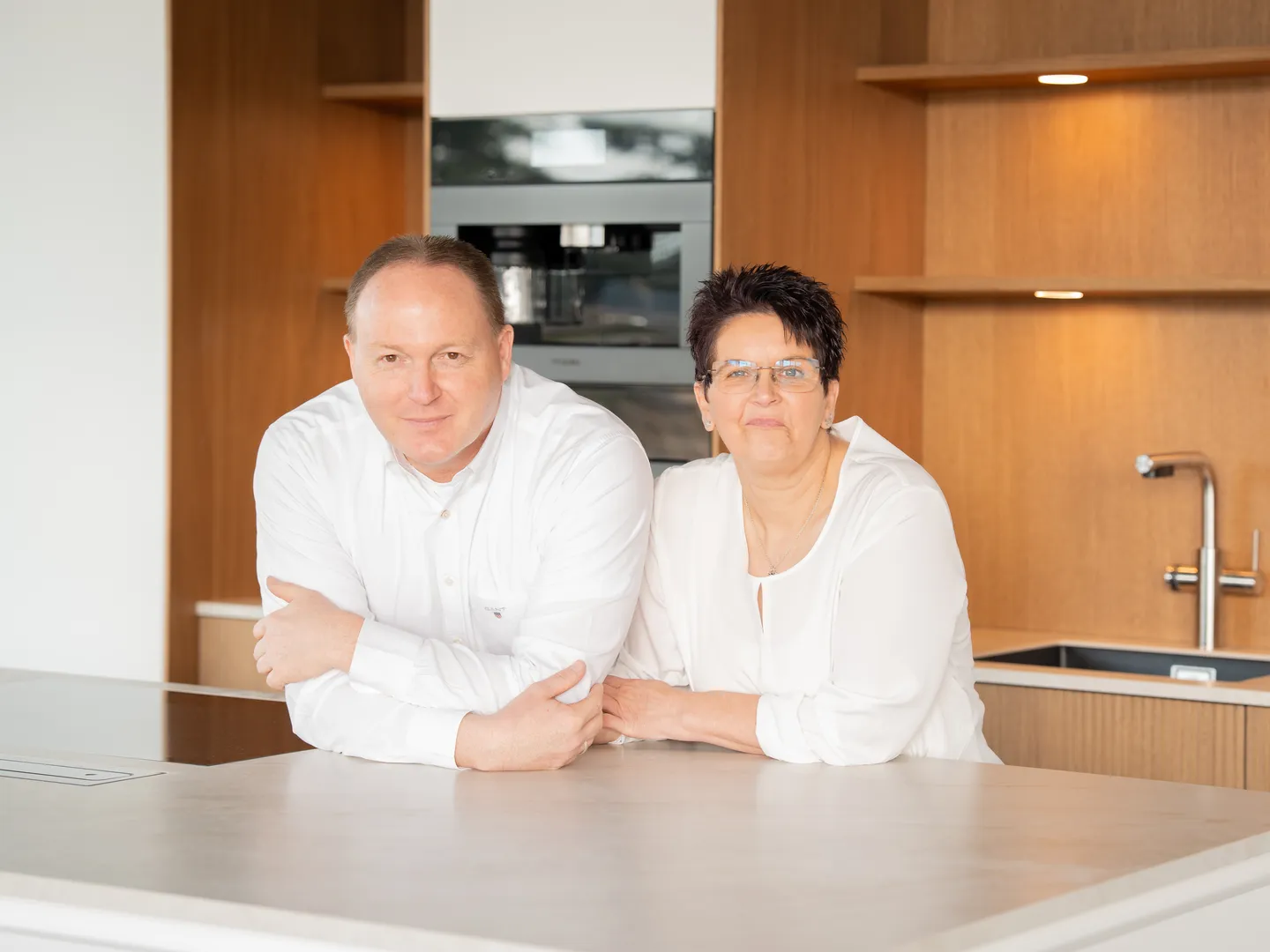 Frank und Sabine Hollmann, Inhaber der homestyle gmbh, an einer Kücheninsel im Einrichtungsstudio