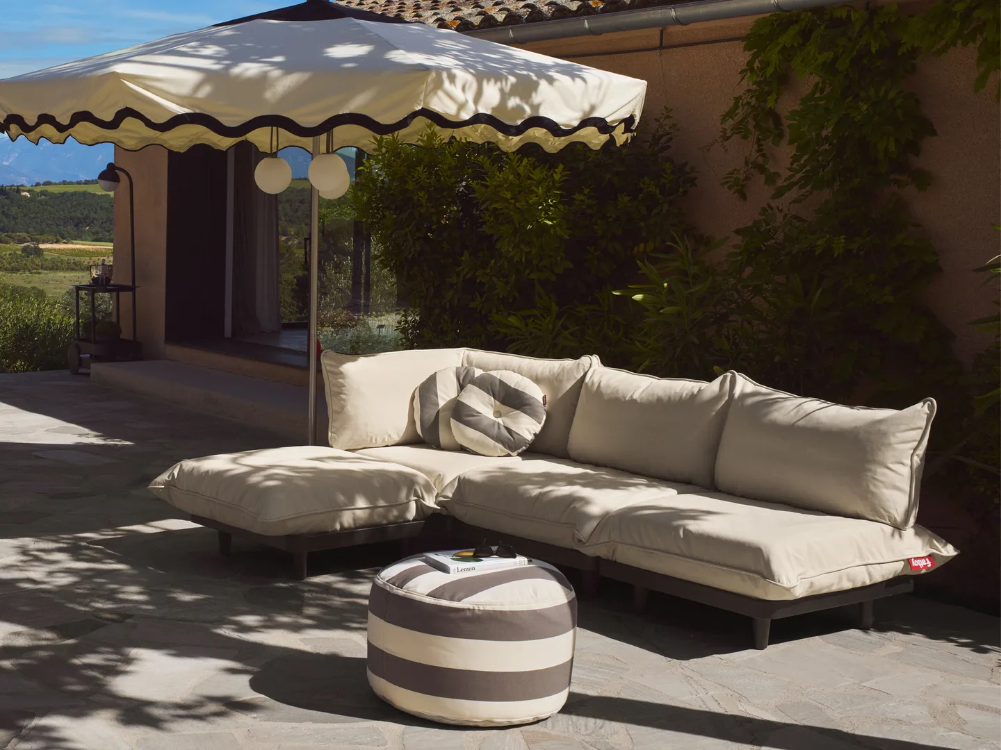 Outdoor-Sofa und Sonnenschirm im Garten